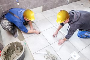 Workers placing tiles on the floor
