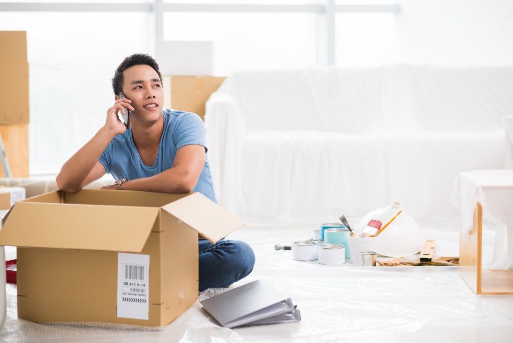 Man talking over the phone while packing