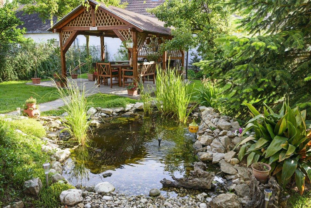 Landscaped backyard with pond and cottage