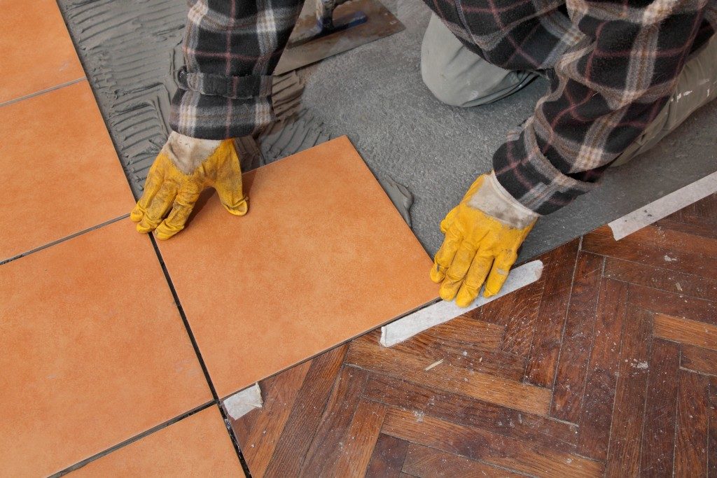man installing floor tiles