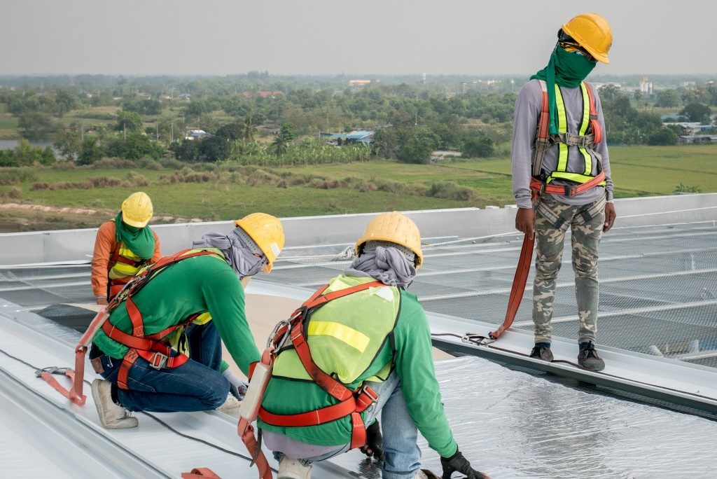 Workers fixing flat roof