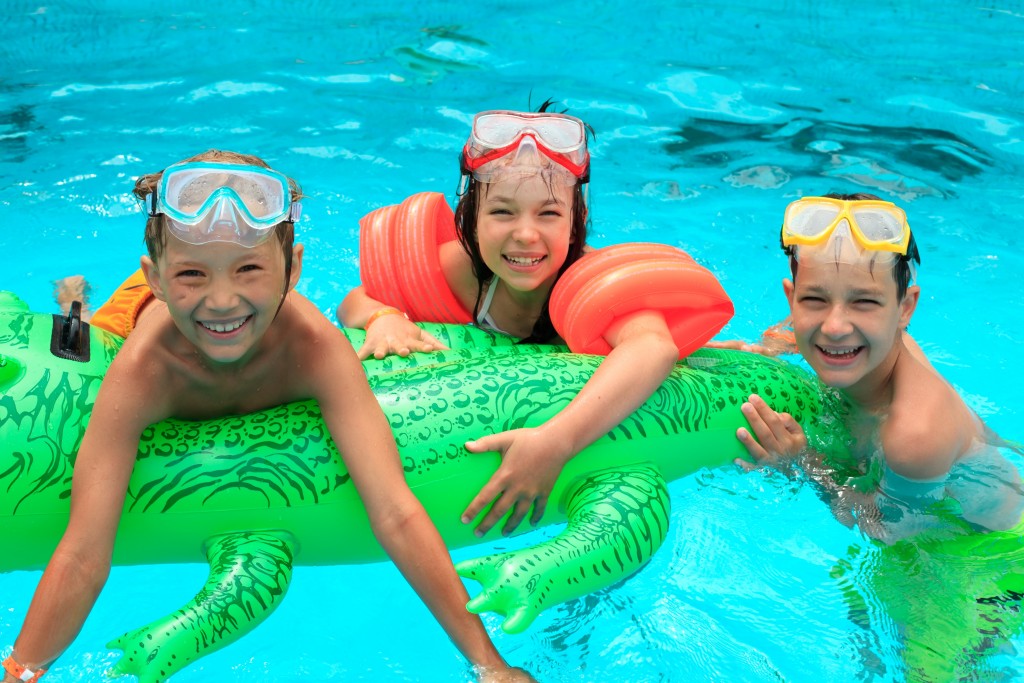Children inside the pool with floaters