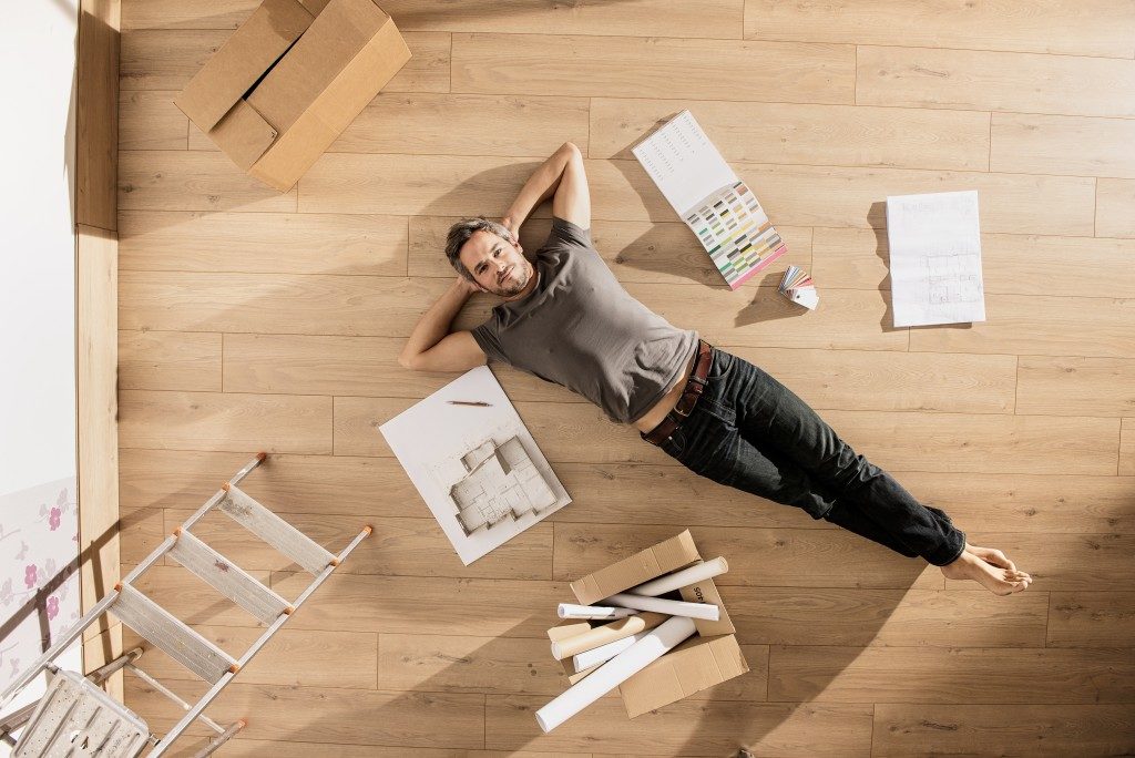 Man lying on the floor beside design materials