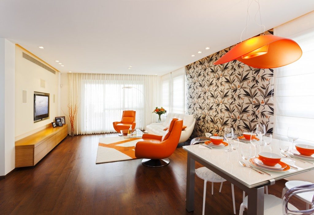 small room with touch of orange interior and wood flooring