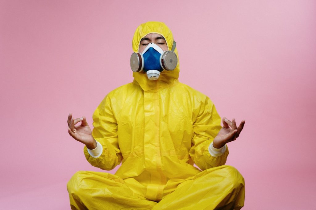 man wearing PPE meditating